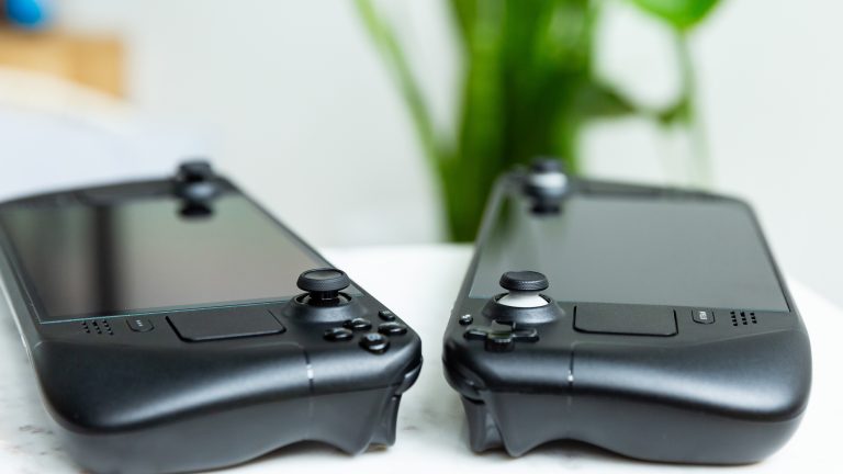 Zwei Steam Decks, ein LCD- und ein OLED-Modell, liegen nebeneinander auf einem Tisch.